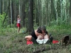 Old couple with a youthfull redhead in the forest