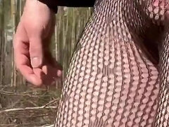 Walking in a park in fishnet tights.