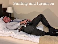 A man in a suit cums while playing with a dildo