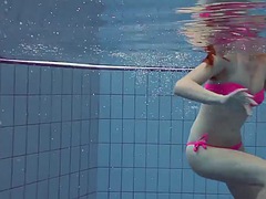 Beauty in a pink swimsuit Lera shows a naked body under water